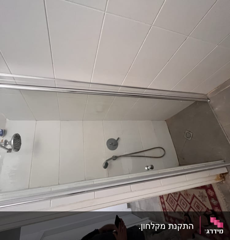 מקלחת עם ראש מקלחת ודלת זכוכית